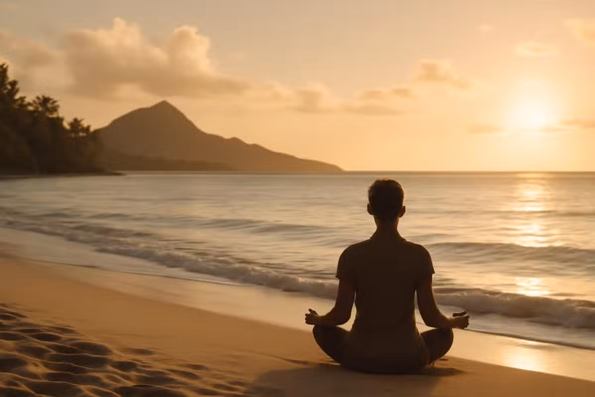 Pessoa meditando em praia havaiana ao nascer do sol, transmitindo paz e conexão interior