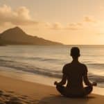 Pessoa meditando em praia havaiana ao nascer do sol, transmitindo paz e conexão interior
