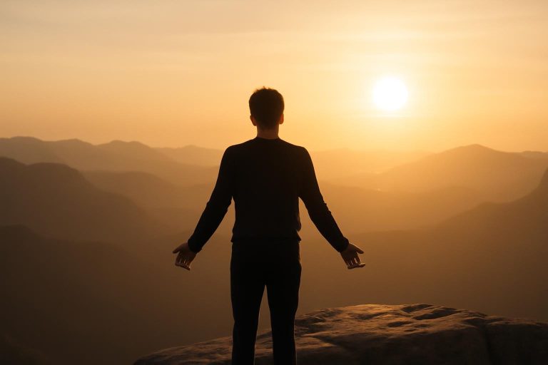 Pessoa em pé diante de paisagem ao amanhecer, simbolizando entusiasmo como energia interna que move ações.